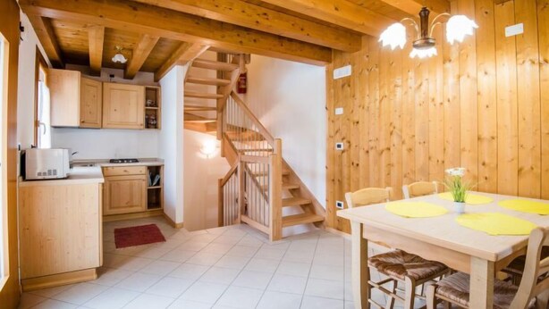 A wooden interior with a kitchen, dining area, and staircase. - Albergo Diffuso - Cjasa Paron Cilli by Interhome (Barcis Lake)