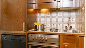 Una cocina con armarios de madera, un lavavajillas Siemens, un horno Siemens y un salpicadero de azulejos.