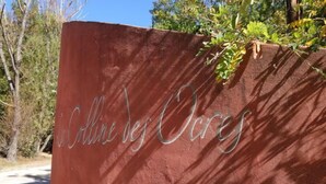 Uma parede vermelha com a inscrição “Colline des Oiseaux” em letra cursiva.