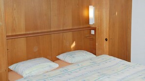 A wooden bunk bed with a headboard and a bedside table. - Residenza Corallo by Interhome (Ascona)