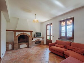 A living room with a fireplace, a sofa, and a television.