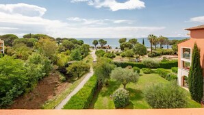 A coastal property with a paved pathway leading to a beach, surrounded by lush greenery and Mediterranean-style architecture. - Les Rivages des Issambres by Interhome (Les Issambres)