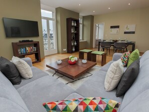 A living room with a sofa, coffee table, and a TV. - Elegance by Interhome (Interlaken)