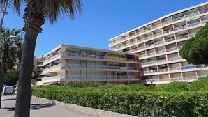A multi-story hotel with balconies, a flat roof, and a clear blue sky. - Le Méditerranée by Interhome (Fréjus)