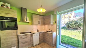 Een moderne keuken met houten kastjes, een inbouwoven en een vaatwasser.