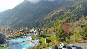 Un resort con varias piscinas, un campo de golf y vistas a una cordillera.
