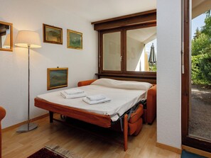 Un dormitorio con una cama, una lámpara de noche y cuadros en la pared.