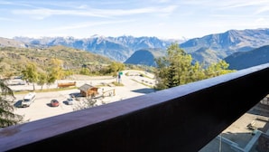 Bergblick mit Straße, einem kleinen Gebäude und einigen parkenden Autos.