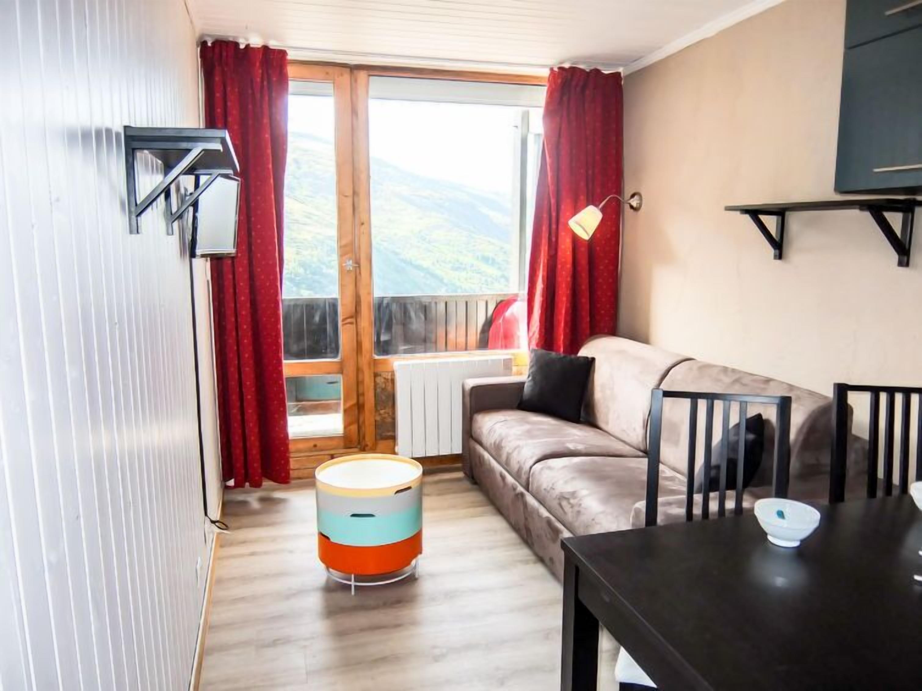A cozy room with a sofa, a table, a lamp, and a radiator.