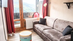 Una sala acogedora con un sofá, una mesa redonda y vistas al exterior.