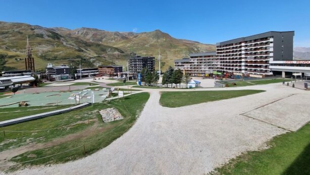 Un hotel de varios pisos, con un patio central y montañas al fondo.