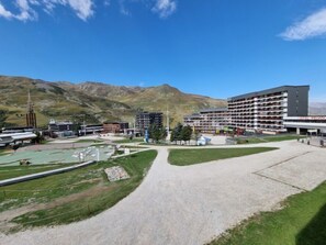 A hotel with multiple floors, a central courtyard, and a mountainous backdrop.