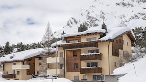 Ein mehrstöckiges Hotel mit Balkonen und einem Berg im Hintergrund.