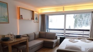 A modern hotel room with a sofa, a dining table, and a bed. - Rosablanche D12 by Interhome (Siviez-Nendaz)