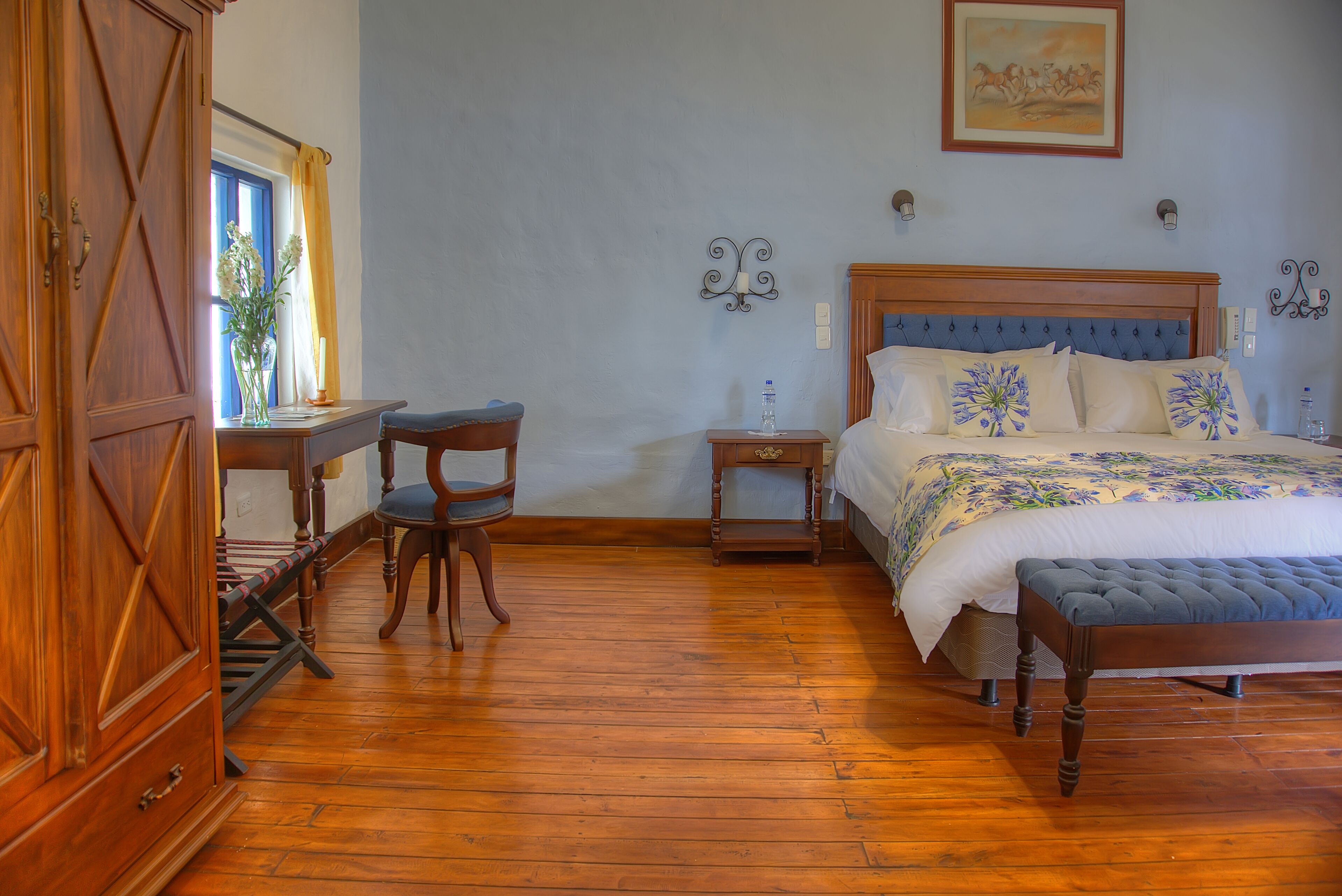 Un dormitorio con una cama de madera, un escritorio y una silla.