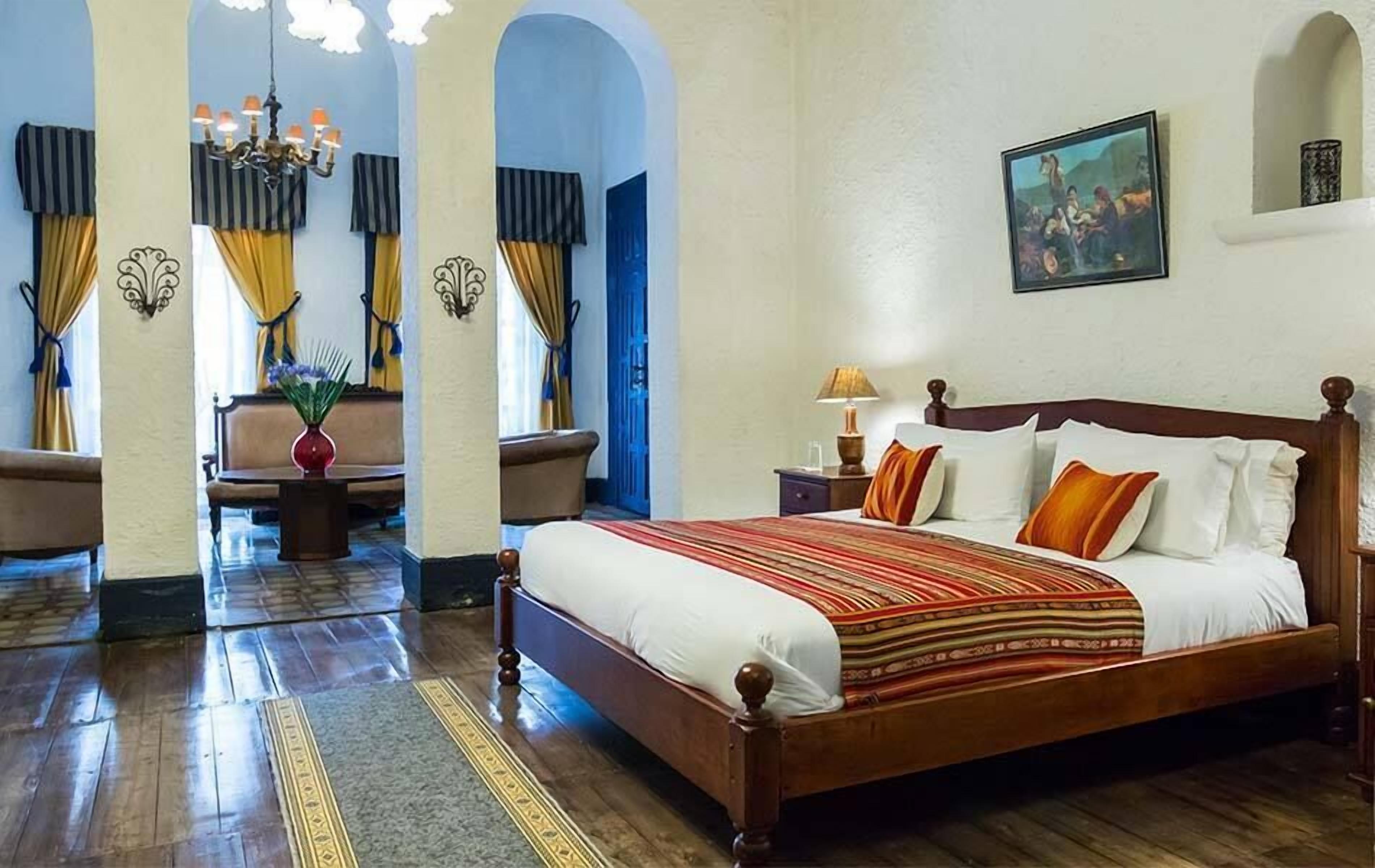 Un dormitorio con una cama de madera, una mesita de noche, una lámpara y un cuadro en la pared.