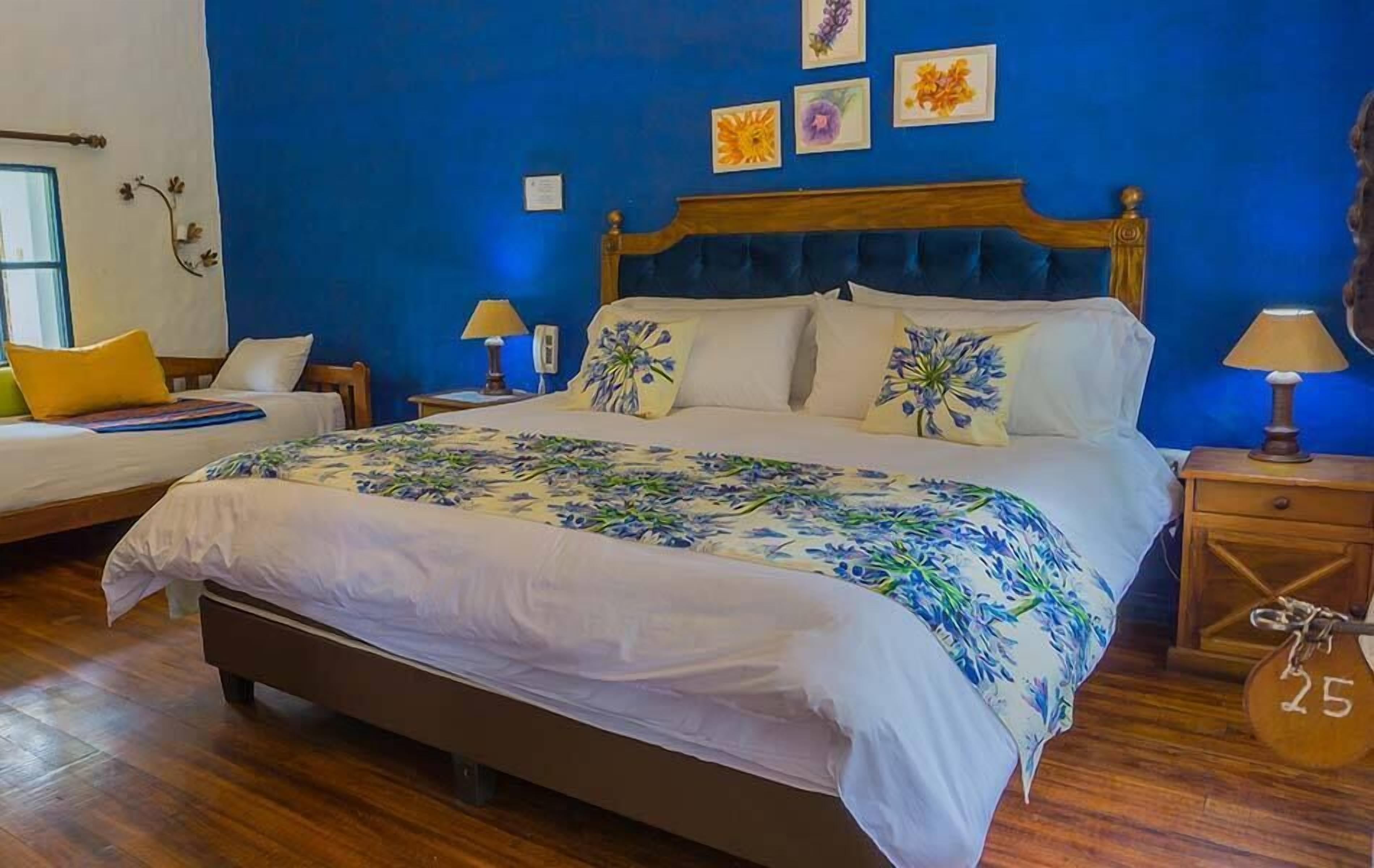 A bedroom with a large bed, two bedside tables, and a wooden floor.