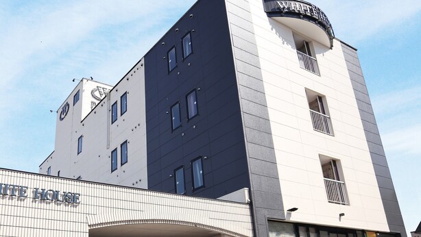 A hotel with a modern design, featuring a large entrance and multiple windows. - Hotel New White House (Rumoi)