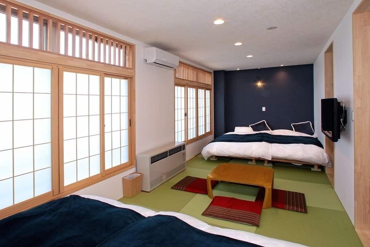 Una habitación con dos camas, televisión y un ventanal con vistas.