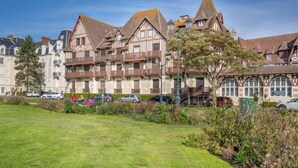 Un edificio in stile europeo tradizionale, con numerosi balconi e un giardino curato di fronte.
