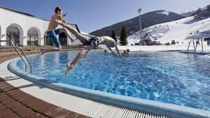 A swimming pool with a person jumping into it.