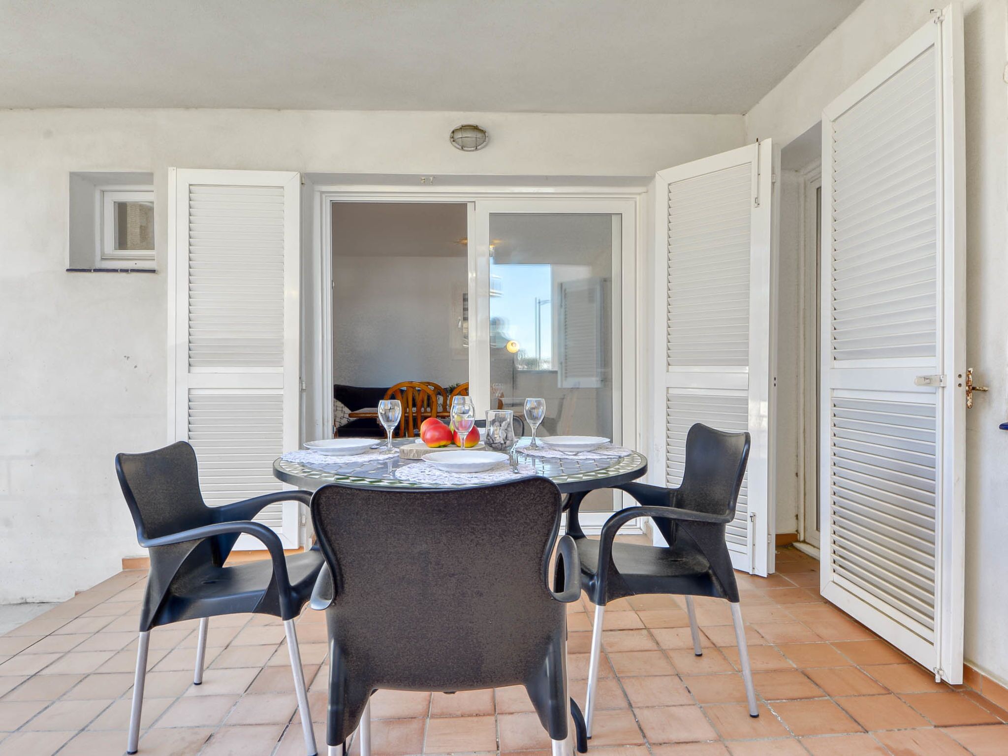 A dining area with a round table set for four, surrounded by chairs.