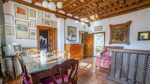 Un coin repas avec une table et des chaises en bois, un coin cuisine équipé d’un four à micro-ondes et un coin salon avec un canapé à motifs.