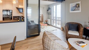 Een moderne woonruimte met keuken, eethoek en zithoek met uitzicht op de omgeving.