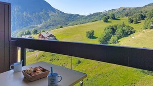 Een balkon met een tafel, een mok en een mand met brood.