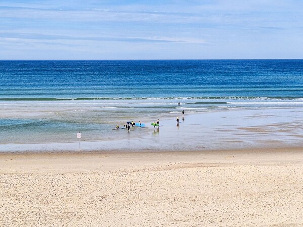A beach with people walking and carrying surfboards. - Vacation home Poste by Interhome (Mimizan)