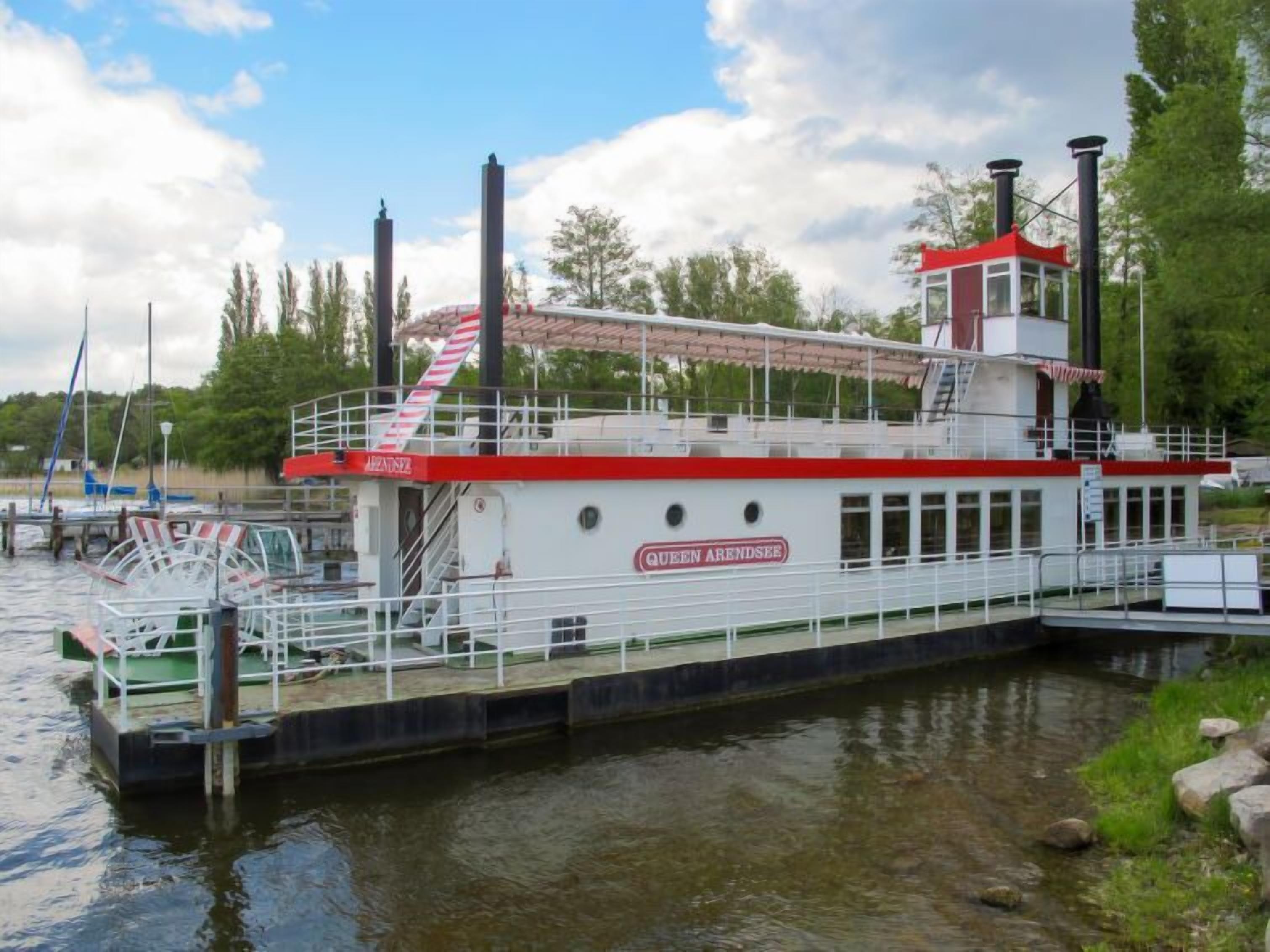 Ein großes Flusskreuzfahrtschiff namens "Queen Arendsee" liegt an einem Steg festgemacht.