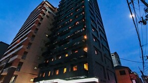 Un hotel de diverses plantes amb un cartell ben visible de "HOTEL LIVEMAX" a la planta baixa.