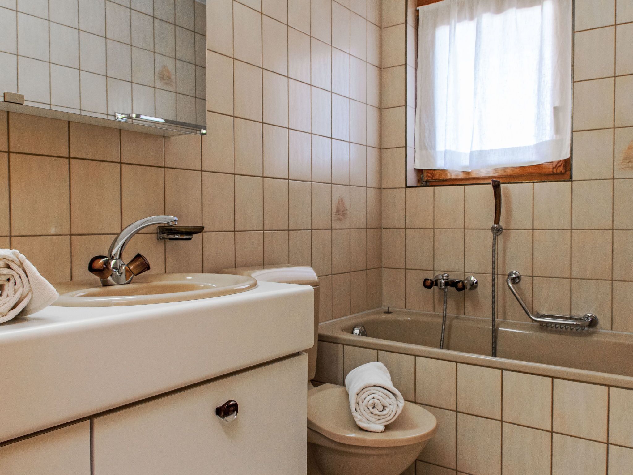Un baño con lavamanos, inodoro y bañera.