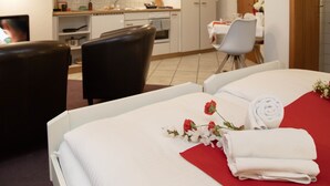 Ein Hotelzimmer mit Bett, Schreibtisch, Stuhl und einer Küchenzeile.