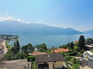 Eine Küstenstadt mit Gebäuden, einem See und Bergen im Hintergrund.