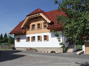 A two-story house with a red-tiled roof, wooden window shutters, and a white facade. - Apartment Lärche by Interhome (Grosserlach)