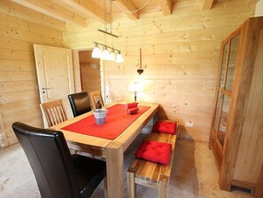A wooden interior with a dining table, chairs, a bench, and a lamp. - Apartment Lärche by Interhome (Grosserlach)