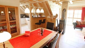 A cozy loft-style room with a dining area, kitchen, and living space. - Apartment Lärche by Interhome (Grosserlach)