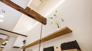 A room with wooden beams, a hanging plant, and a shelf with a notebook. - Japan Sessions KANZAKI 01 (Osaka)