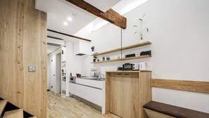 A modern kitchen with wooden cabinetry, a built-in oven, and a microwave. - Japan Sessions KANZAKI 01 (Osaka)
