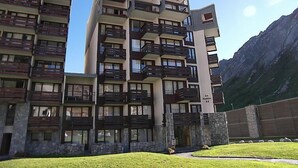 A multi-story hotel with balconies, stone facade, and a mountainous backdrop. - Les Moutières B1 et B2 (Val Claret) by Interhome (Tignes)