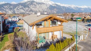 A modern chalet with a wooden exterior and large windows, set against a backdrop of snow-capped mountains. - Apartment Lanner by Interhome (Axams)