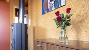 A wooden cabinet with a vase of red roses on top.