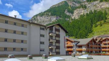 Un hôtel au design moderne, avec de nombreux étages et une vue imprenable sur les montagnes.