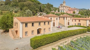 A villa with multiple buildings, a central courtyard, and a hilltop view.
