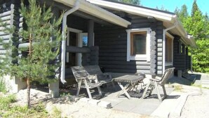 A log cabin with a porch, two lounge chairs, and a small table. - Metsämarja by Interhome (Kemiönsaari)