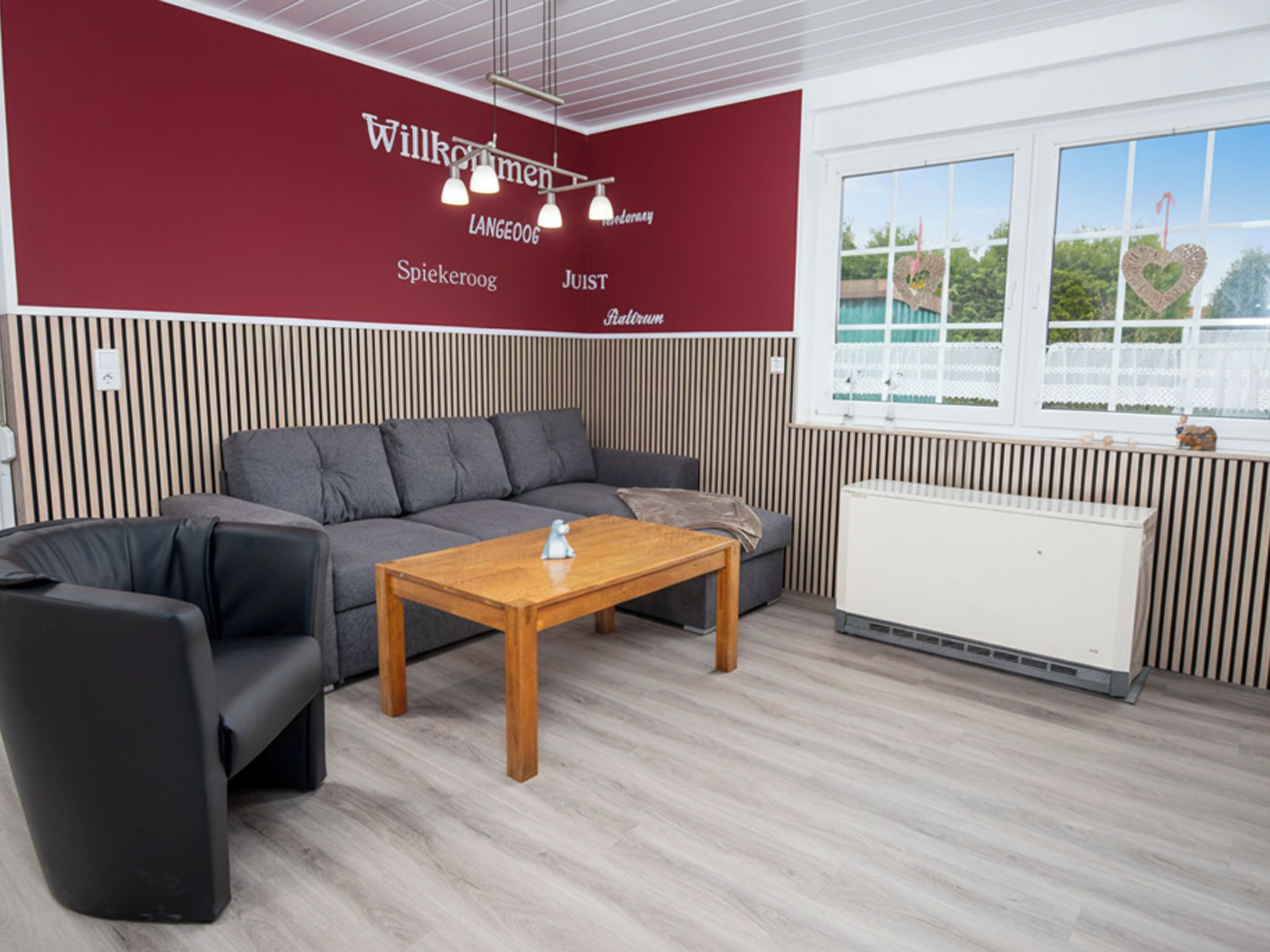 A modern room with a grey sofa, a wooden table, and a radiator.