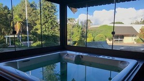 Ein Whirlpool mit freiem Blick auf die umliegenden Bäume und ein Gebäude im Hintergrund.