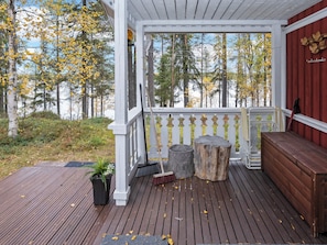 A wooden deck with a white railing, a bench, and a table.