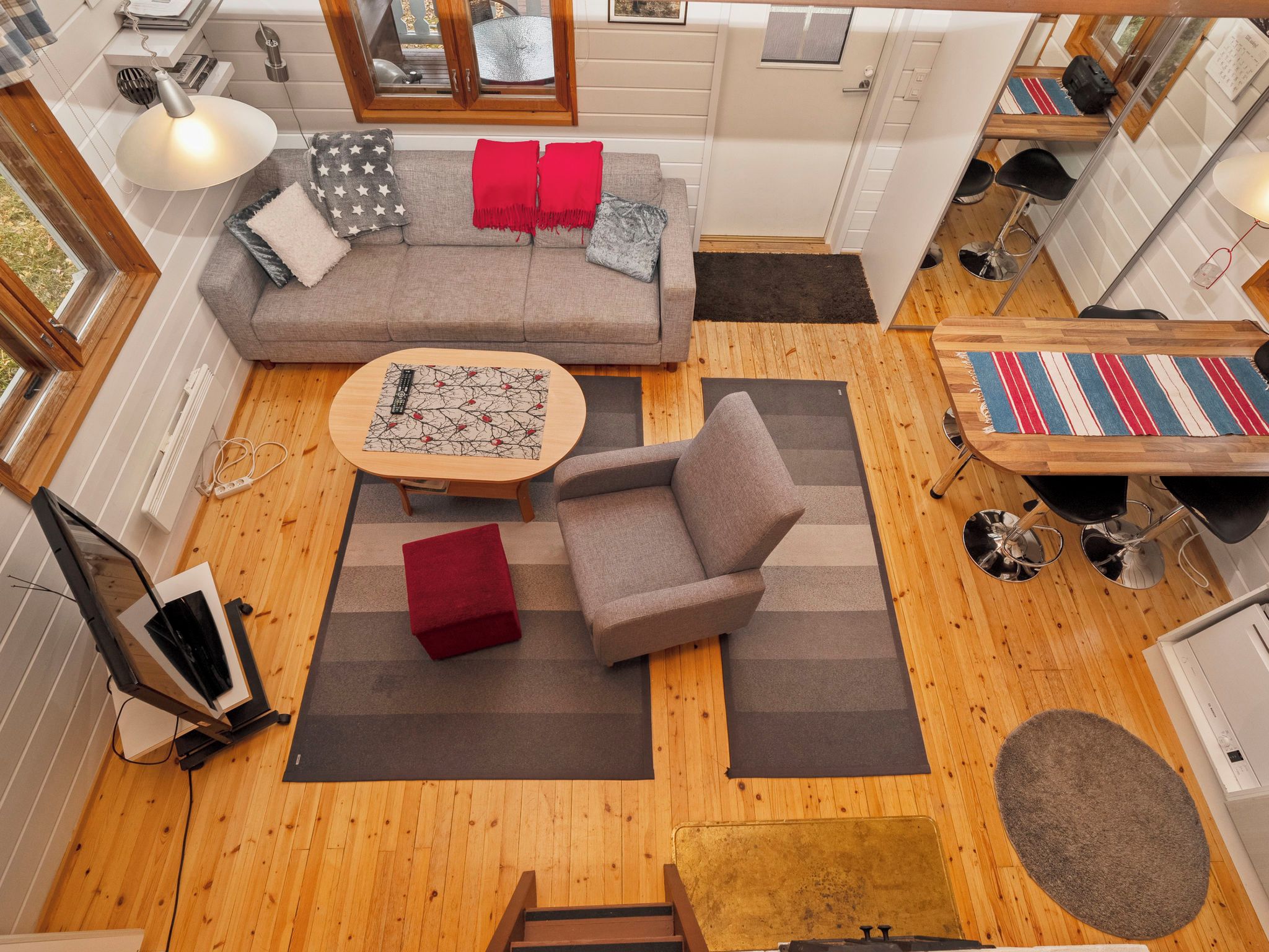 A compact living space with a sofa, armchair, coffee table, and a small dining area.